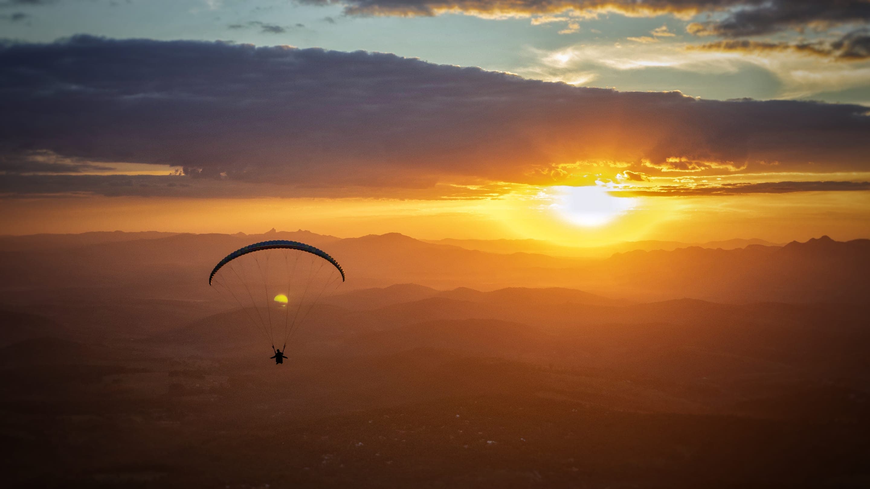 Parapente ao pôr do sol sobre a Serra da Moeda, em Brumadinho, Minas Gerais